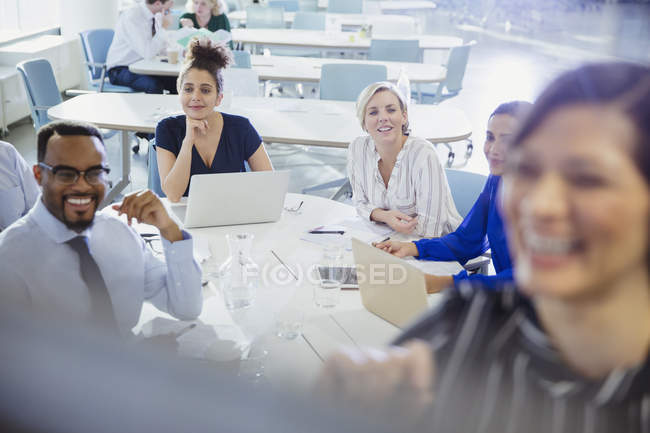 Gente de negocios con ordenadores portátiles escuchando en la sala de conferencias - foto de stock