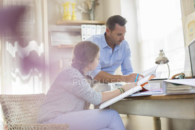 Padre aiutare figlia adolescente con i suoi compiti — Foto stock