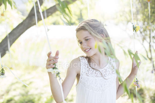 Smiling bridesmaid playing with decorations in domestic garden during wedding reception — Stock Photo