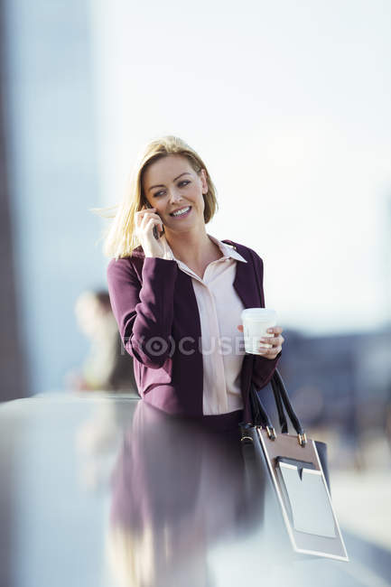 Femme d'affaires parlant sur un téléphone portable en ville — Photo de stock
