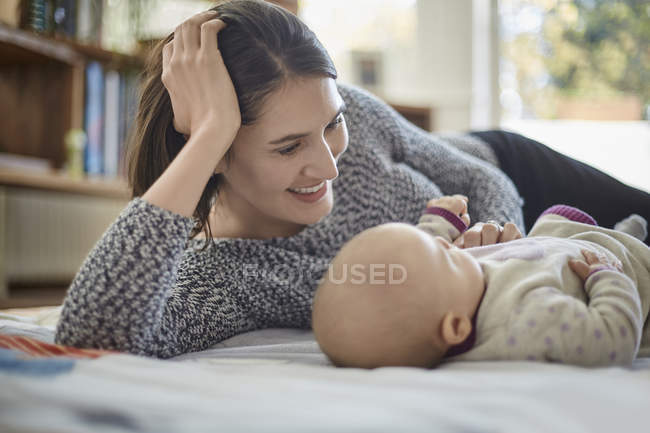 Sorrindo mãe olhando para bebê filha — Fotografia de Stock