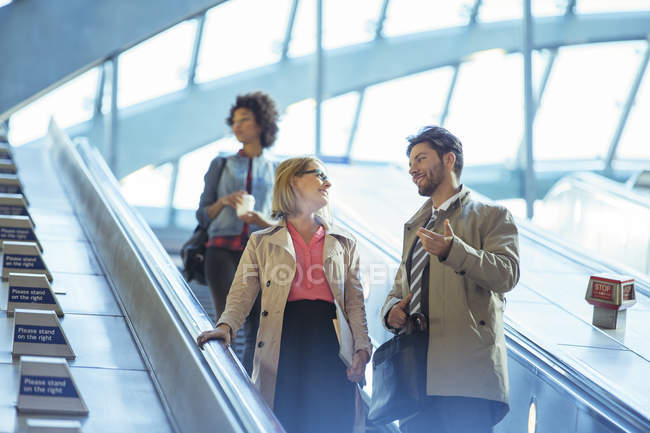 Business people talking on escalator — Stock Photo