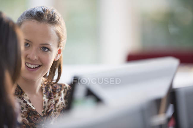 Donne d'affari sorridenti a computer in ufficio — Foto stock
