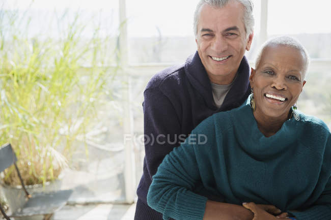 Ritratto sorridente coppia anziana che abbraccia sul portico del sole — Foto stock