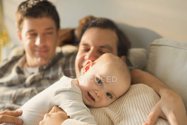 Retrato bonito bebê filho abraçando com masculino gay pais — Fotografia de Stock