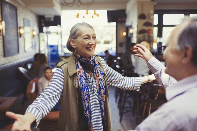 Enthusiastic couple greeting and hugging in bar — Stock Photo