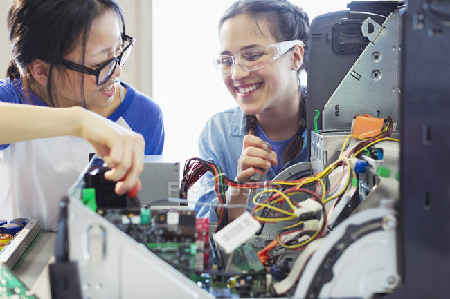 Smiling girl students assembling computer in classroom — Stock Photo