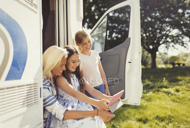 Мати і дочки використовують цифровий планшет за межами сонячного двигуна будинку — стокове фото