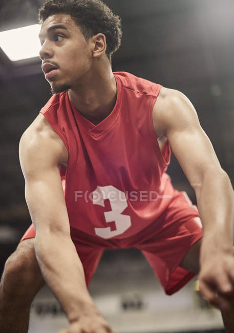 Determinado joven jugador de baloncesto masculino driblando la pelota - foto de stock