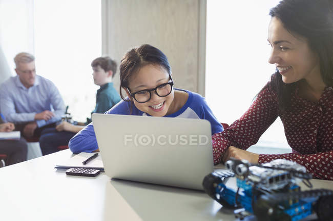 Femme enseignante et fille étudiante programmant la robotique à l'ordinateur portable en classe — Photo de stock