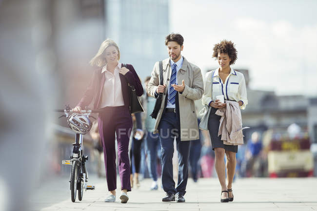 Gente de negocios caminando y hablando en la ciudad - foto de stock