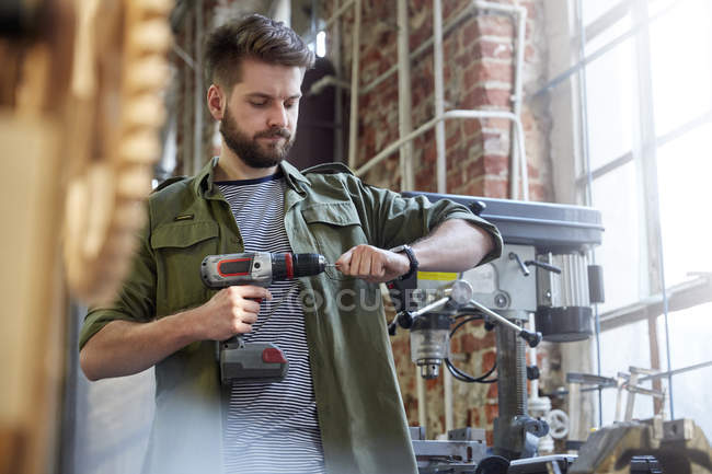 Designer using power drill in workshop — Stock Photo