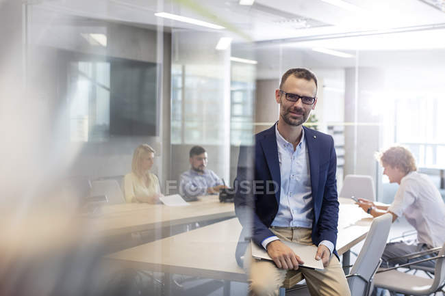 Портретний бізнесмен тримає ноутбук у конференц-залі — стокове фото