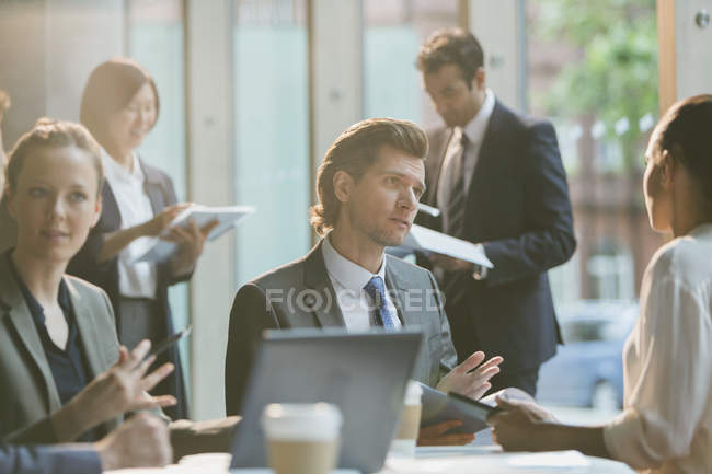 Hombre de negocios serio hablando con la mujer de negocios en la reunión de la sala de conferencias - foto de stock