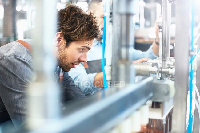 Male brewer bottling beer in brewery — Stock Photo
