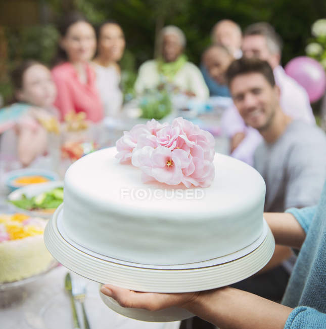 Cercano pastel fondant blanco con flores de color rosa - foto de stock