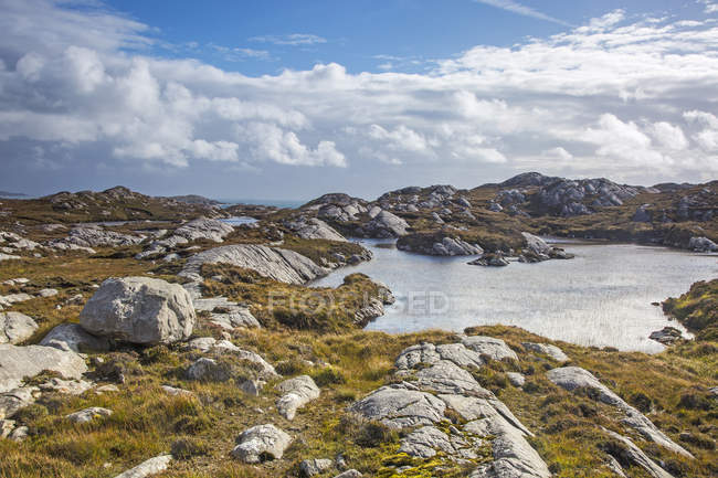 Sunny clouds over craggy rocks and water, Golden Road, Harris, Outer Hebrides — Stock Photo