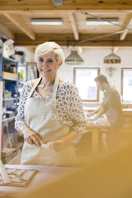 Portrait smiling stained glass artist working in studio — Stock Photo