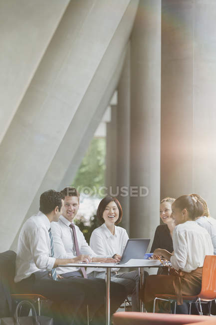Gli uomini d'affari sorridenti che parlano in sala conferenze — Foto stock