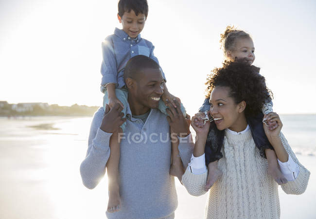 Familia feliz divirtiéndose en la playa - foto de stock