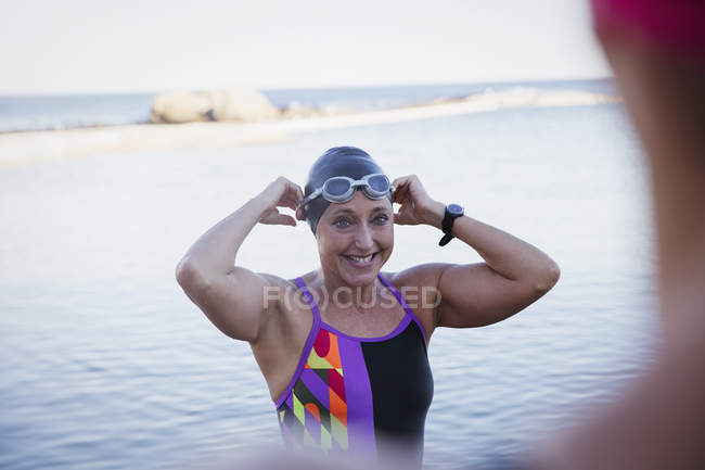 Feminino nadador ativo sorrindo no oceano ao ar livre — Fotografia de Stock