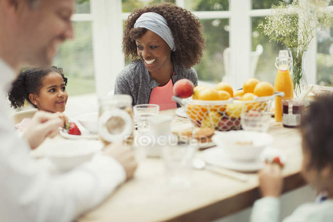 Multi-étnica jovem família tomando café da manhã à mesa — Fotografia de Stock