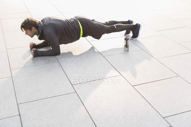 Hombre enfocado haciendo ejercicio de tablón - foto de stock