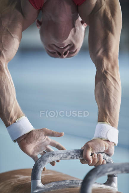 Мужчина гимнаст, выступающий на Поммельской лошади на арене — стоковое фото