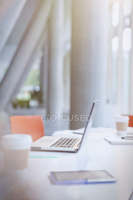 Laptop, coffee and digital tablet on table in office — Stock Photo