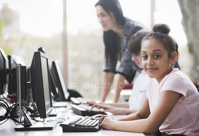 Retrato confiante menina estudante usando computador na biblioteca — Fotografia de Stock