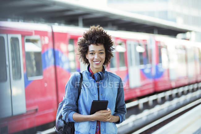 Sorrindo mulher de pé na estação de trem — Fotografia de Stock
