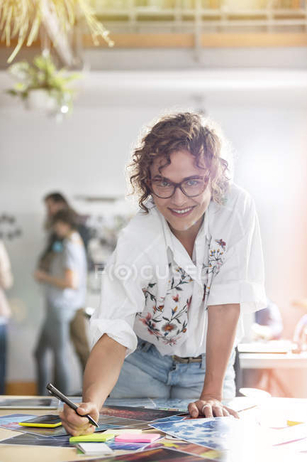 Retrato sorrindo design feminino provas de edição profissional no escritório — Fotografia de Stock