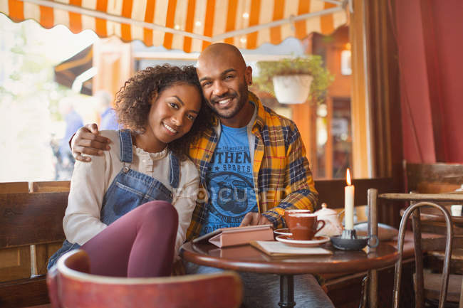 Porträt lächelnd, liebevolles junges Paar, das sich im Café umarmt — Stockfoto