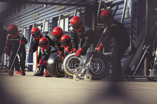 Pit crew preparing tires in formula one pit lane — Stock Photo