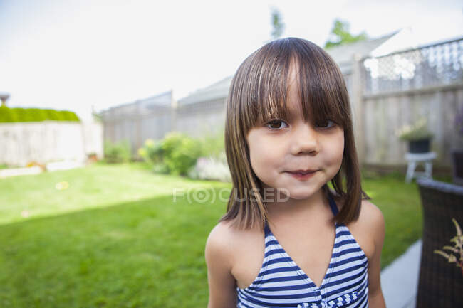 Retrato chica en traje de baño en el patio trasero de verano - foto de stock