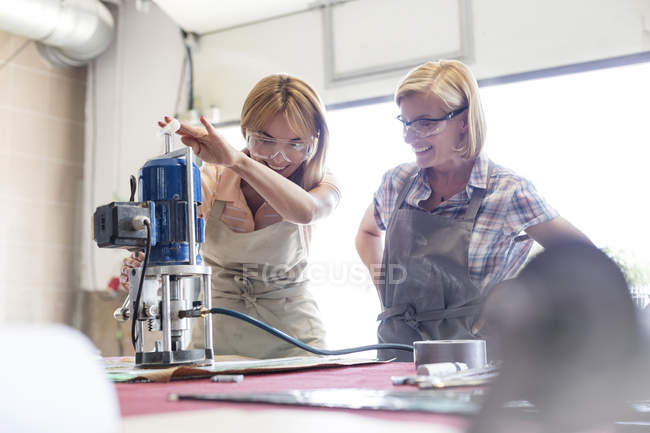 Stained glass artists using equipment in studio — Stock Photo