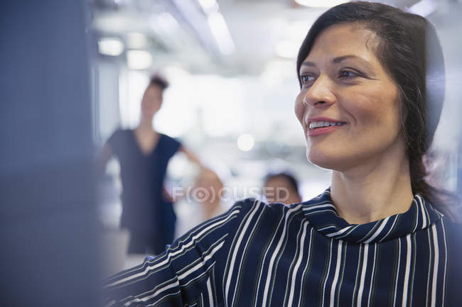 Mujer de negocios sonriente dirigiendo la reunión de la sala de conferencias - foto de stock