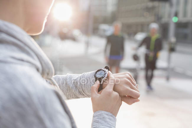 Läuferin checkt Smart-Watch auf Stadtstraße — Stockfoto