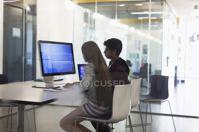 Estudantes que programam em computador em sala de aula — Fotografia de Stock