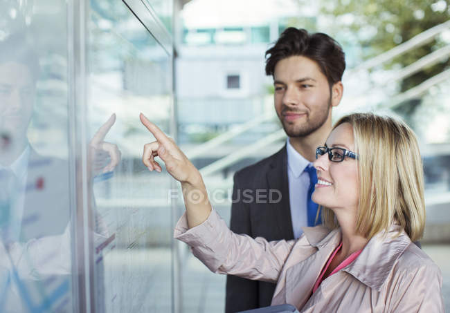 Business people reading transportation schedule — Stock Photo
