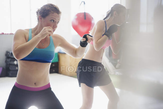 Determined female boxers shadowboxing in gym — Stock Photo