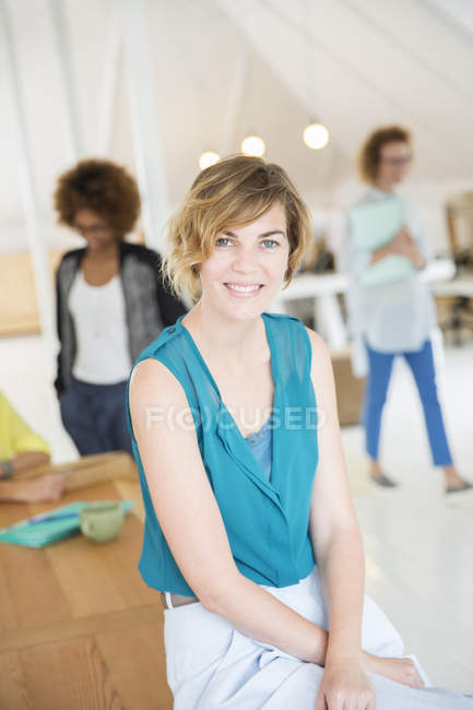 Portrait of young woman smiling at office — Stock Photo