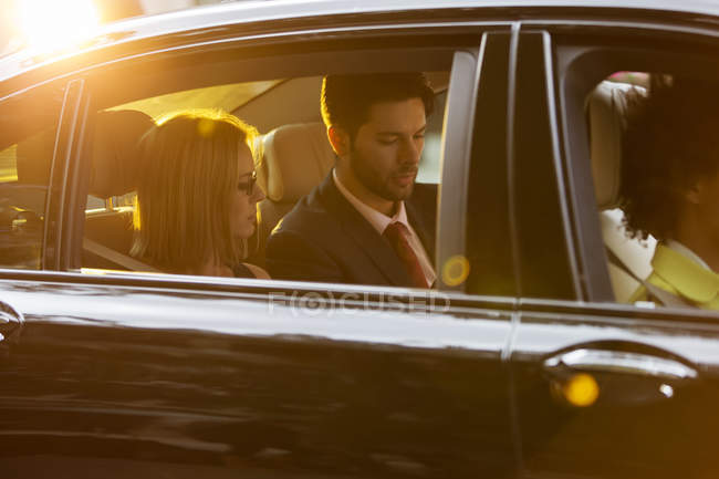 Passengers in back seat of black car — Stock Photo