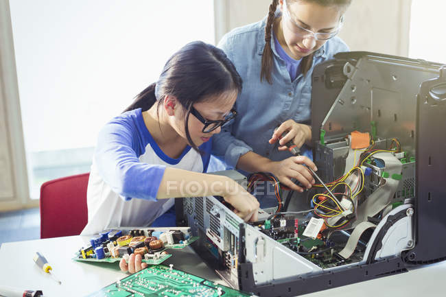 Chicas estudiantes montando computadoras en el aula - foto de stock