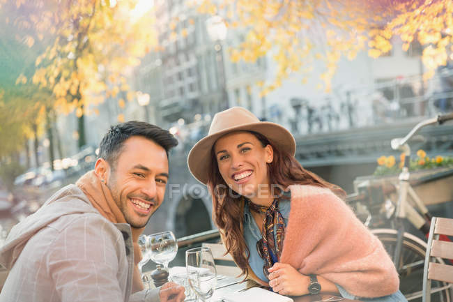 Ritratto sorridente giovane coppia a urbano autunno marciapiede caffè — Foto stock