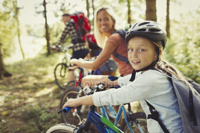 Portrait mother and daughter mountain biking in woods — Stock Photo
