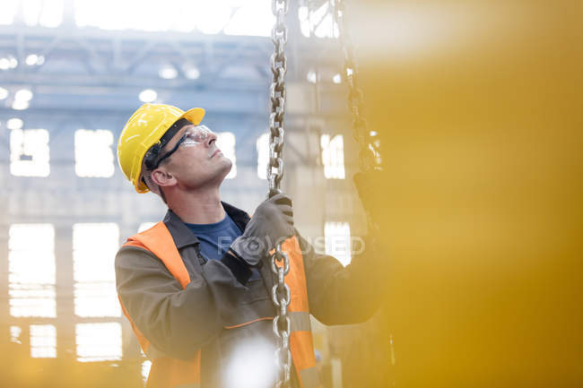 Steel worker holding chain in factory — Stock Photo