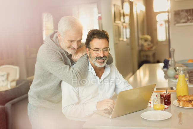 Maschio gay coppia utilizzando laptop a colazione cucina contatore — Foto stock