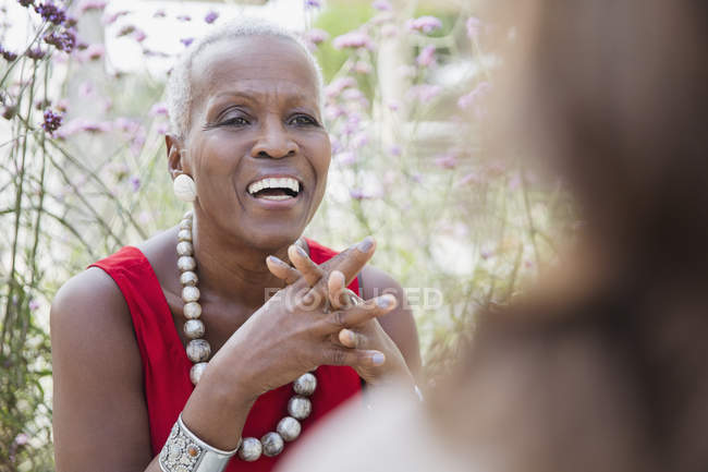 Senior woman laughing, talking with friend — Stock Photo