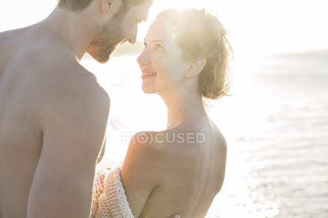 Retrato de una joven pareja sonriente a la luz del sol - foto de stock